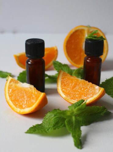 essential oils bottles with orange slices and peppermint